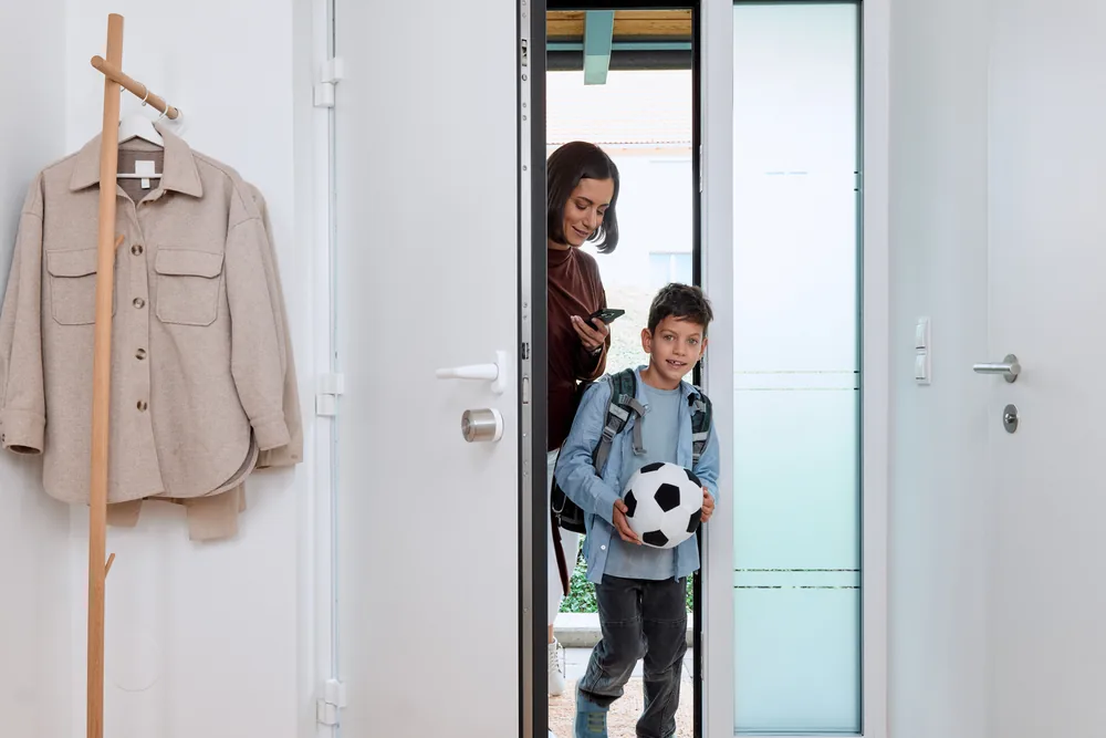 Ingresso di casa con porta dotata di Smart Lock Ultra, famiglia che rientra