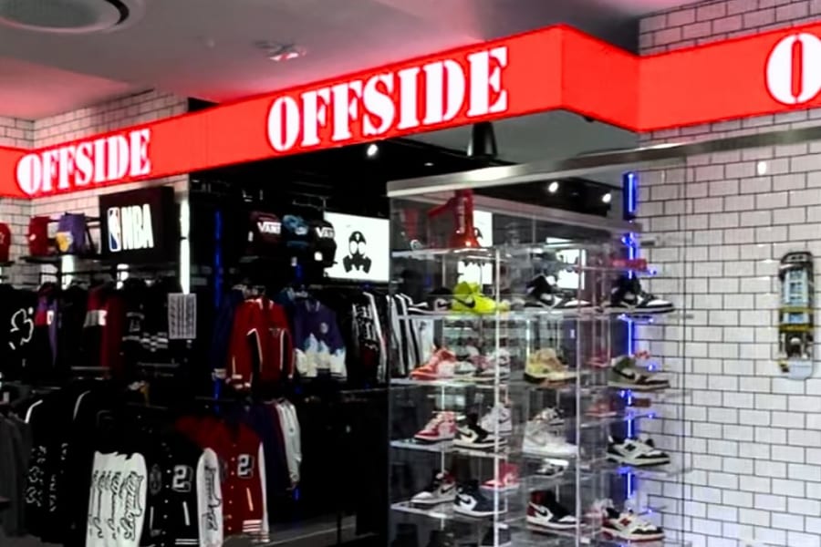Fascia LED rossa accesa con la scritta OFFSIDE che gira attorno all'ingresso dello store di Giugliano